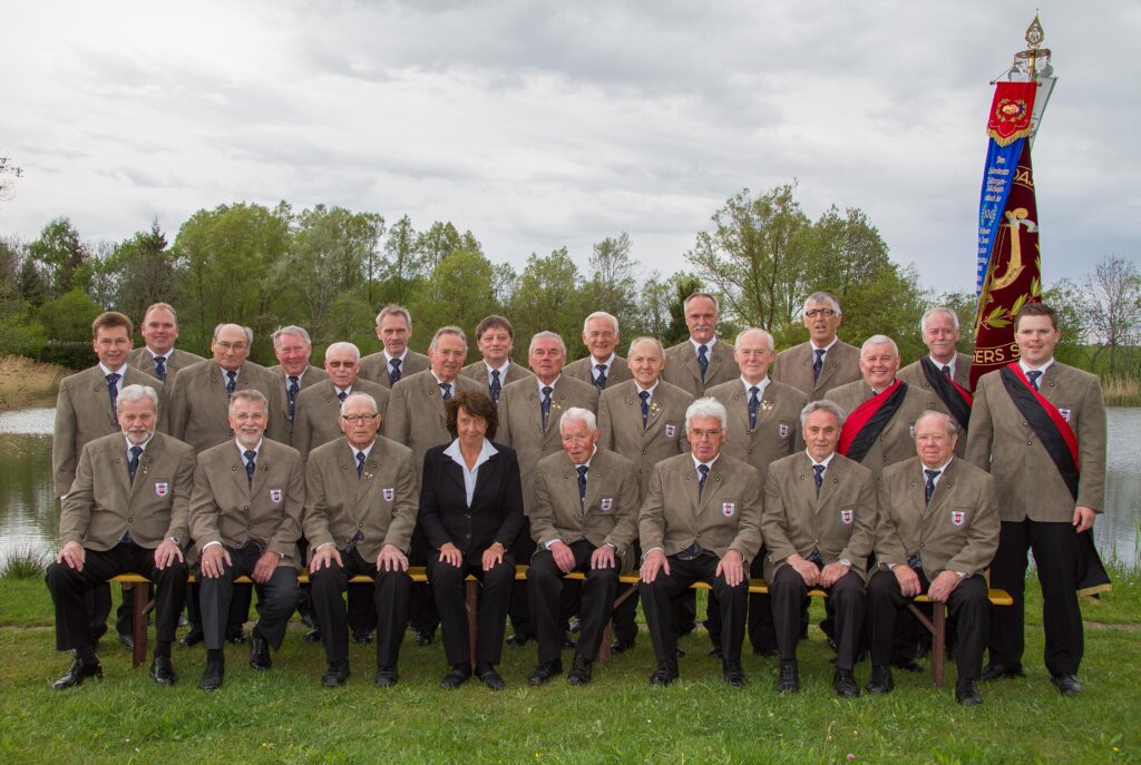Der Chor des MGV Deilingen mit Chorleiterin und Vereinsfahne beim Gruppenfoto am Wasser